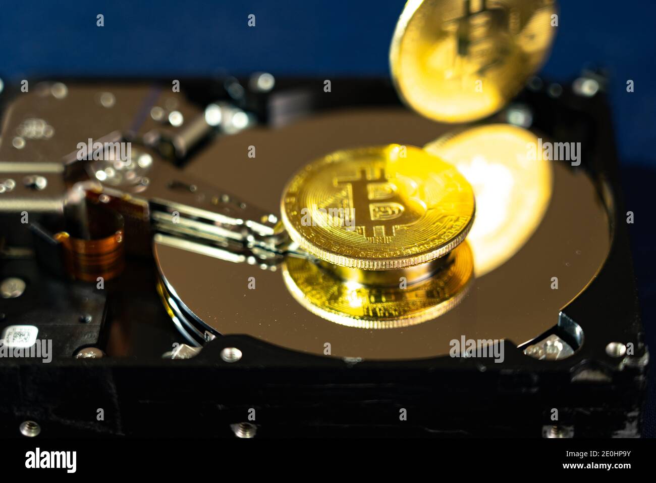 Pièces Bitcoin sur disque dur ou disque dur, macro. Concept de cybersécurité, confidentialité des données. Banque D'Images