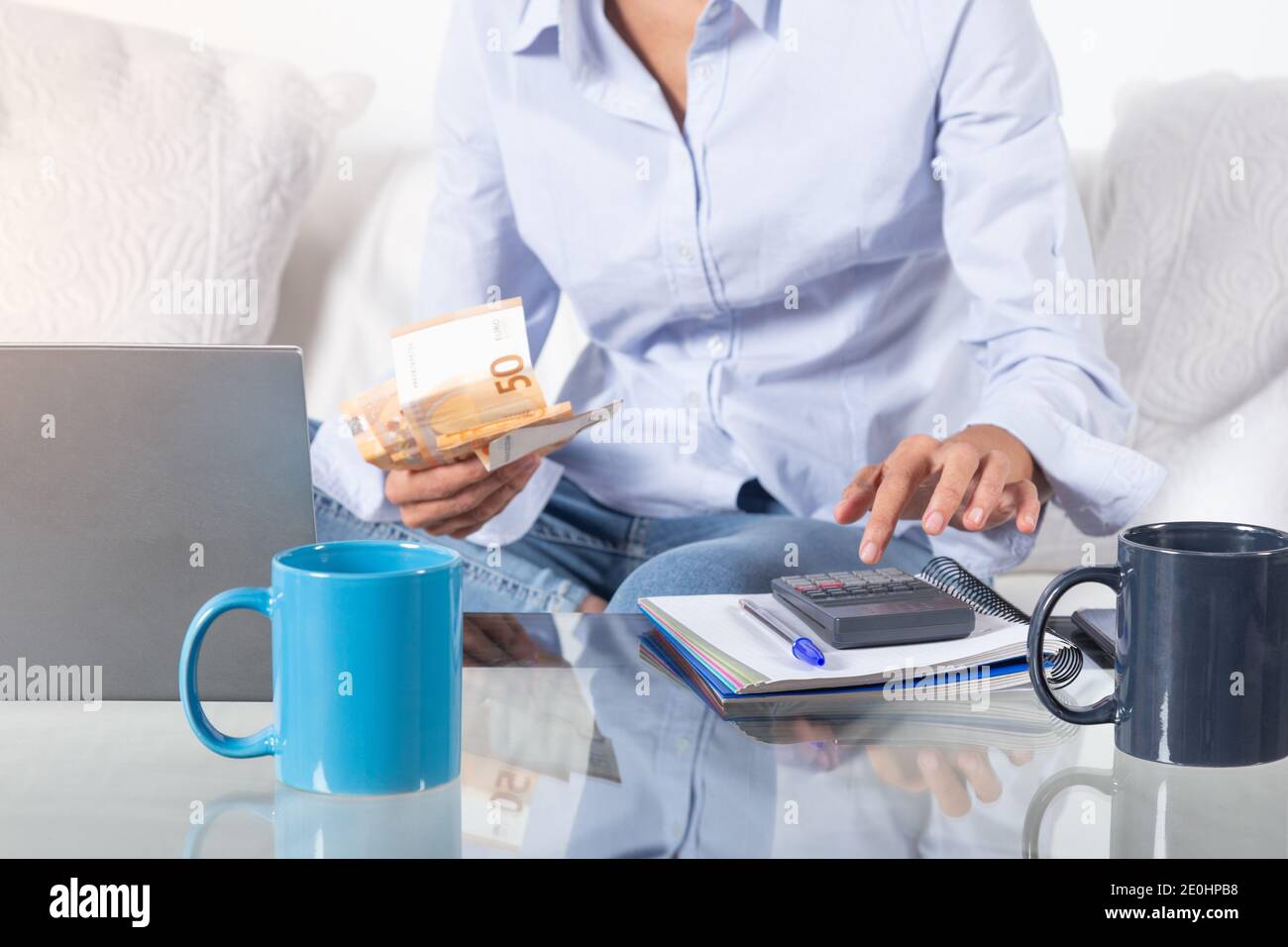 Gros plan les mains des femmes faisant la comptabilité avec la calculatrice et les factures en main, sur le canapé à la maison. Banque D'Images