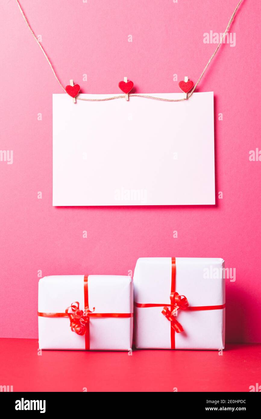 Carte de Saint-Valentin avec coeurs et cadeaux sur fond rose. Concept de San Valentin et d'Amour. Banque D'Images