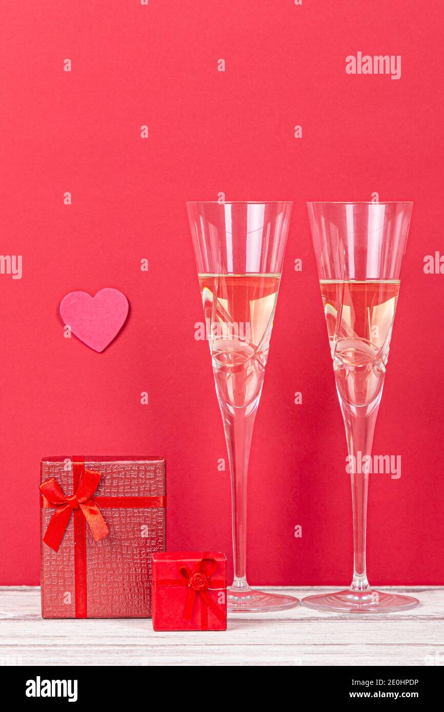 Composition de la Saint-Valentin avec deux verres de champagne, coeur et cadeaux sur fond rouge. concept san Valentin et Love. Banque D'Images