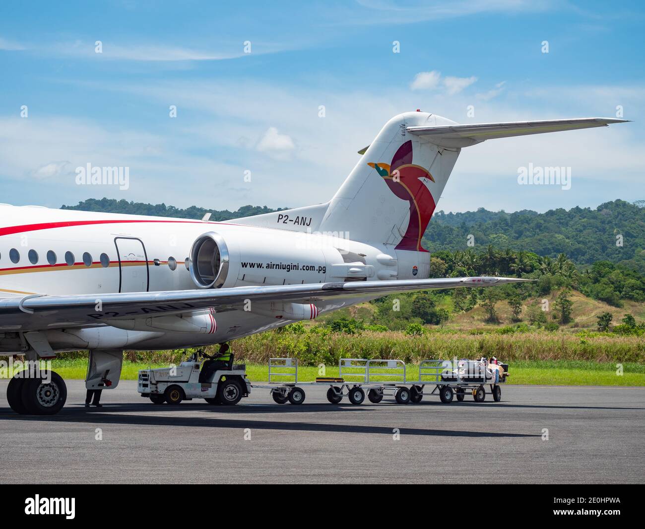 Déchargement de bagages et de marchandises d'un Fokker 100 nommé ville de Lae d'Air Niugini à l'aéroport de Wewak, également appelé aéroport de Boram, à Wewak, la capitale Banque D'Images