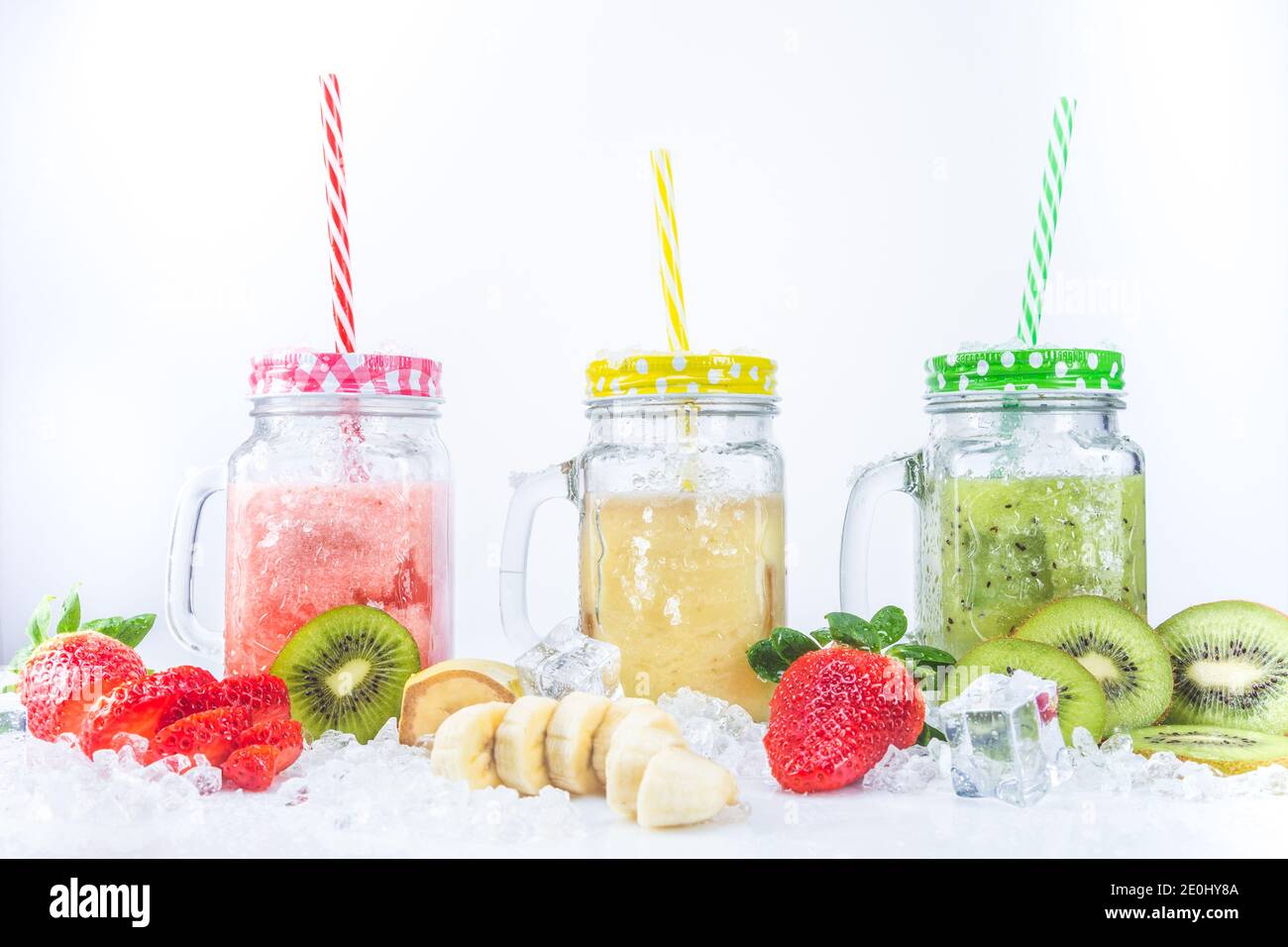 Smoothies frais de fraise Banana et Kiwi, avec morceaux de fruits sur glace, isolés sur fond blanc. Concept de nutrition saine. Banque D'Images