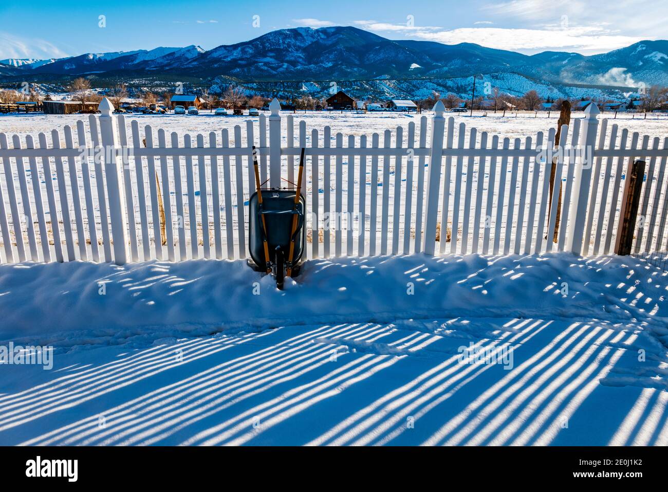 La clôture en vinyle blanc projette de longues ombres hivernales sur la neige fraîche; la montagne méthodiste au-delà; Salida; Colorado; États-Unis Banque D'Images