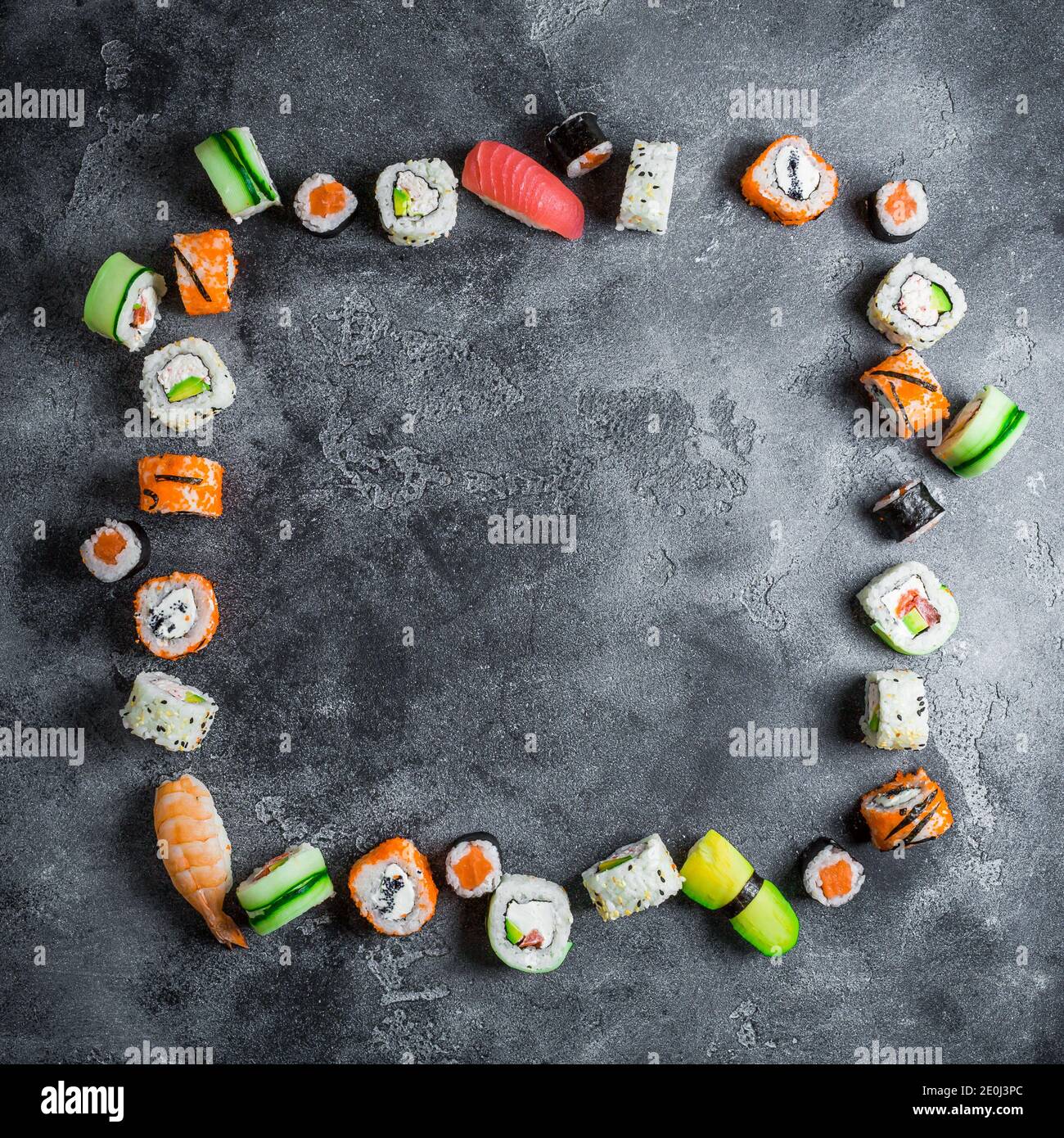 Cadre sushi sur fond sombre. Petits pains à sushis, nigiri, steak de saumon cru, riz et avocat. Pose à plat. Vue de dessus Banque D'Images