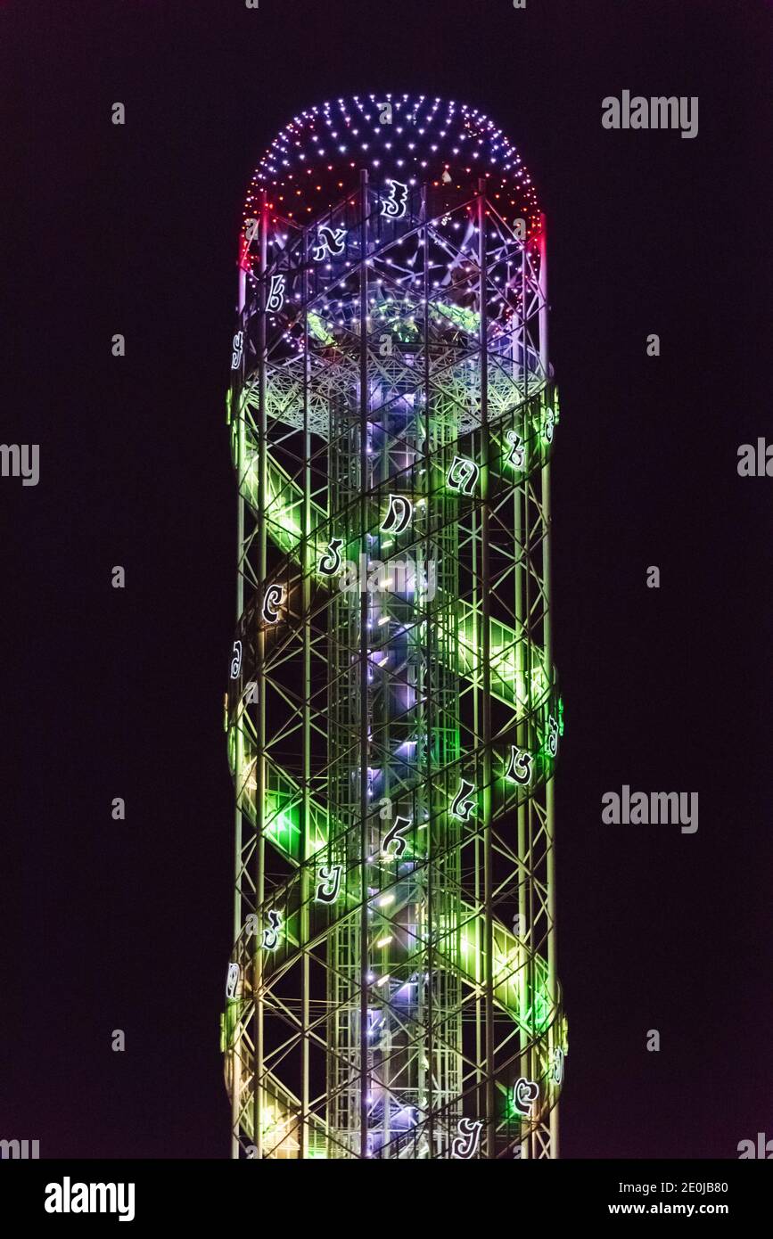 Vue nocturne de la tour Alphabet symbolisant le caractère unique de l'alphabet et du peuple géorgiens, Batumi, Géorgie Banque D'Images
