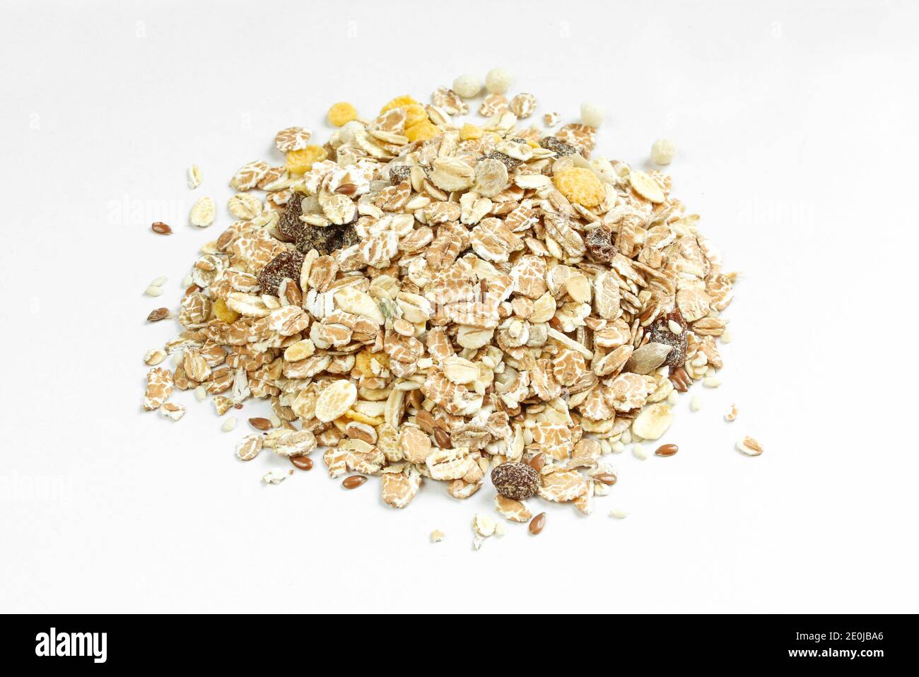 Pile de flocons d'avoine et de raisins secs doux sur fond blanc. Repas de céréales sain Banque D'Images