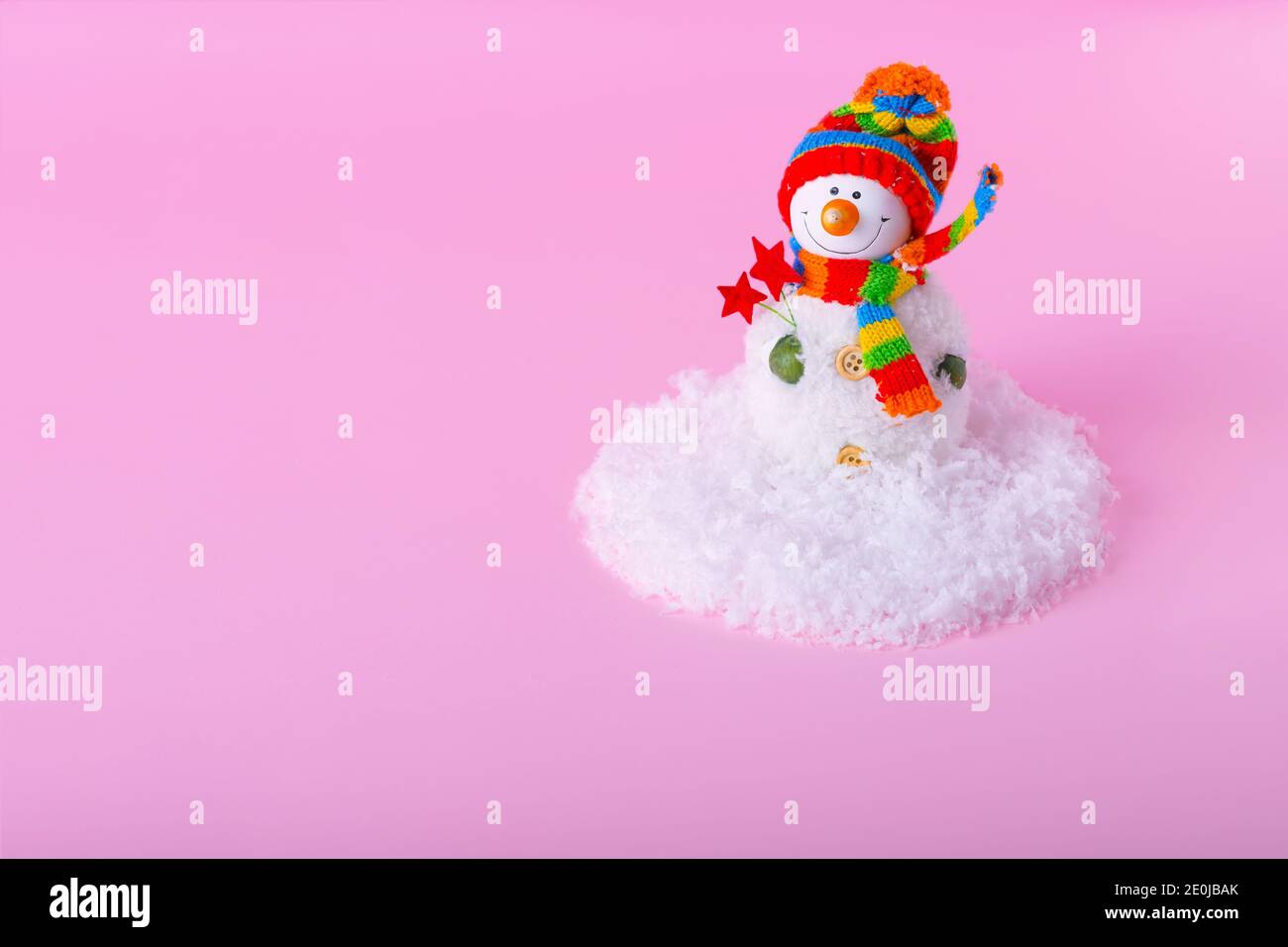 Bonhomme de neige et paysage de neige minimal en hiver sur fond rose clair. Concept de vacances d'hiver. Banque D'Images