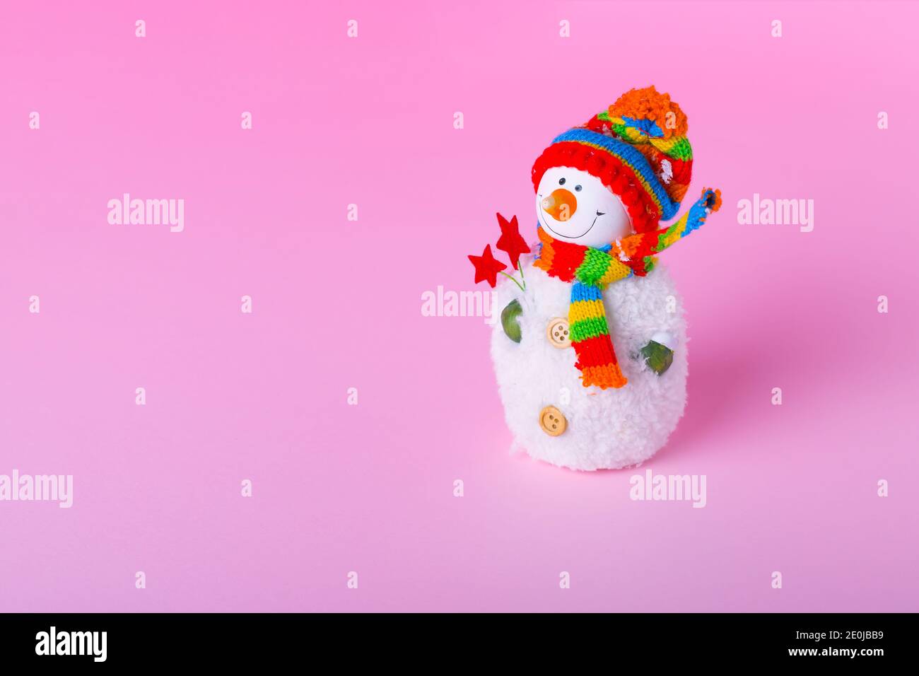 Bonhomme de neige sur fond rose clair. Concept minimal de vacances d'hiver avec espace de copie. Banque D'Images