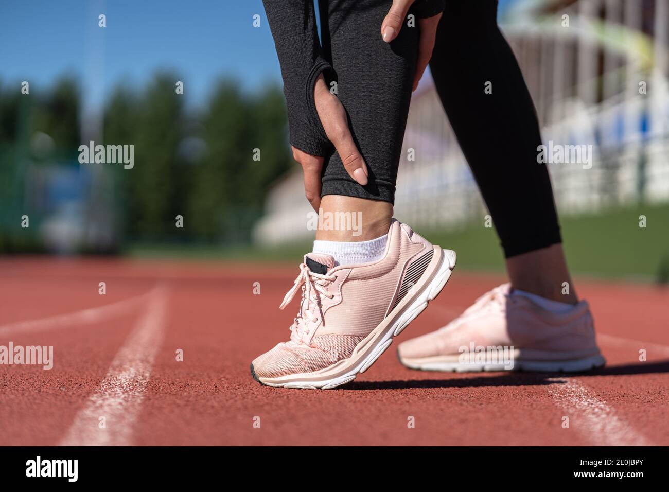 Gros plan d'une femme sportive qui touche le pied dans la douleur due à une cheville tentaculaire. Sport de course, blessure lors de l'entraînement Banque D'Images
