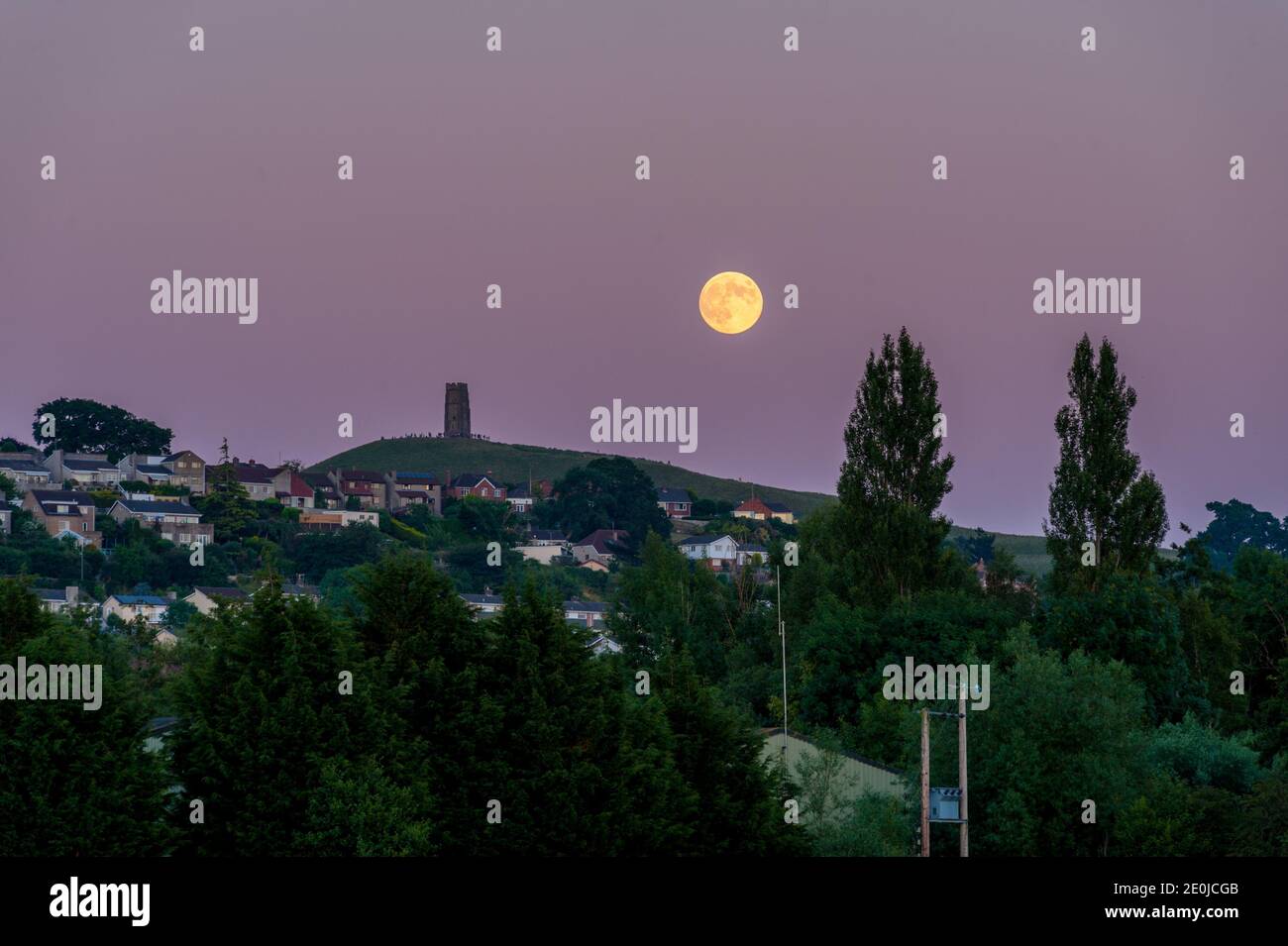 Lune qui s'élève au-dessus de Glastonbury Tor à partir des niveaux de Somerset Banque D'Images