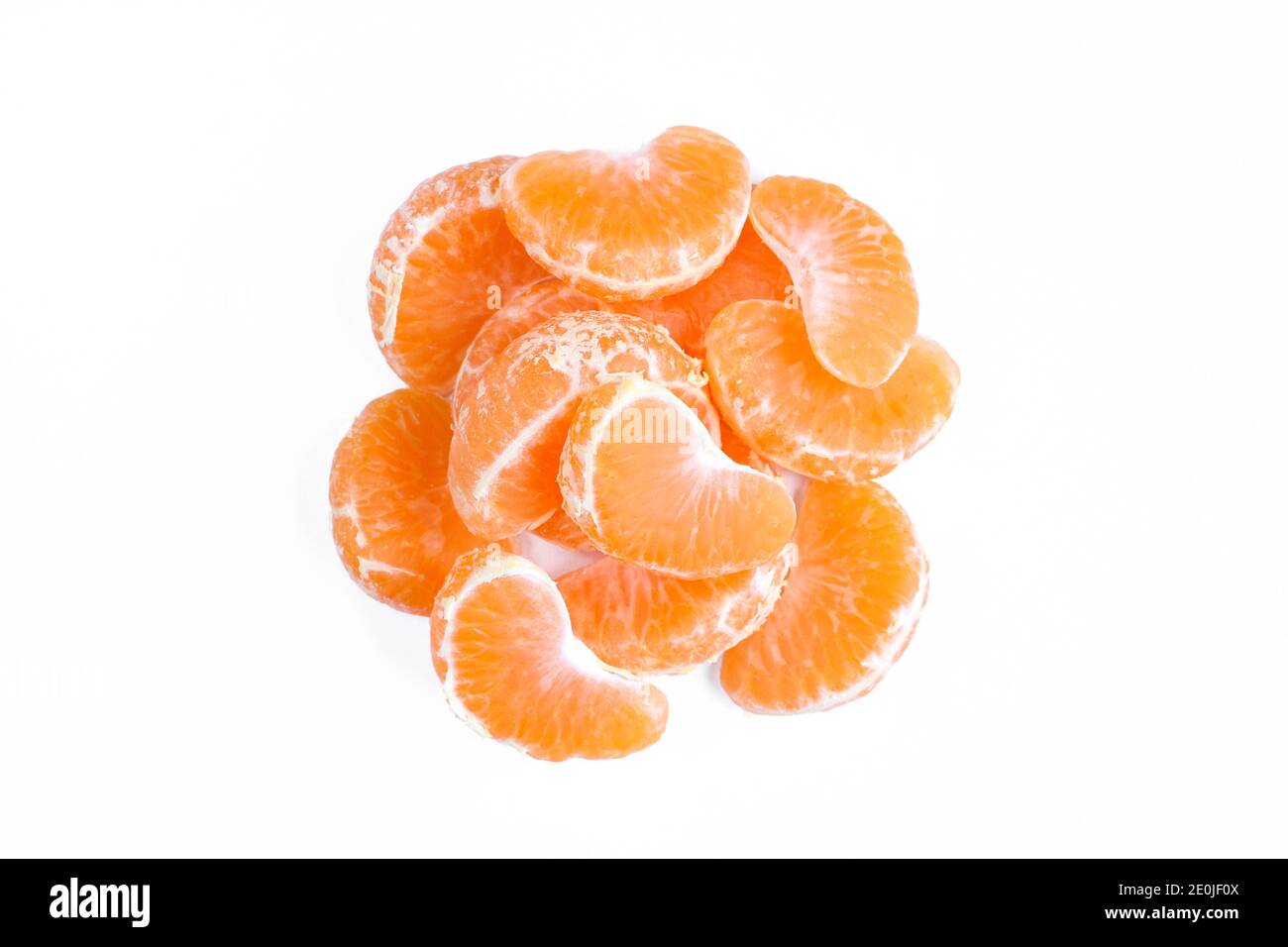 Pile de pièces orange pelées isolées sur fond blanc. Tranches de mandarine juteuses Banque D'Images