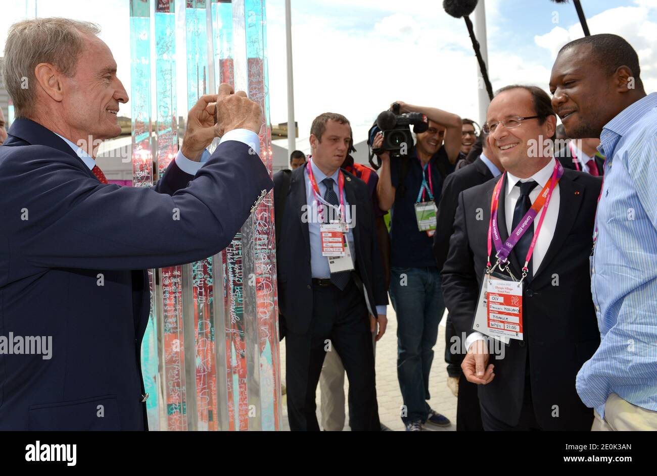 L'ancien skieur Jean-Claude Killy (L) prend une photo du président français François Hollande et d'un invité le 30 juillet 2012 au village olympique de Londres, pendant les Jeux Olympiques de Londres 2012. Photo de Gabriel Bouys/Pool/ABACAPRESS.COM Banque D'Images