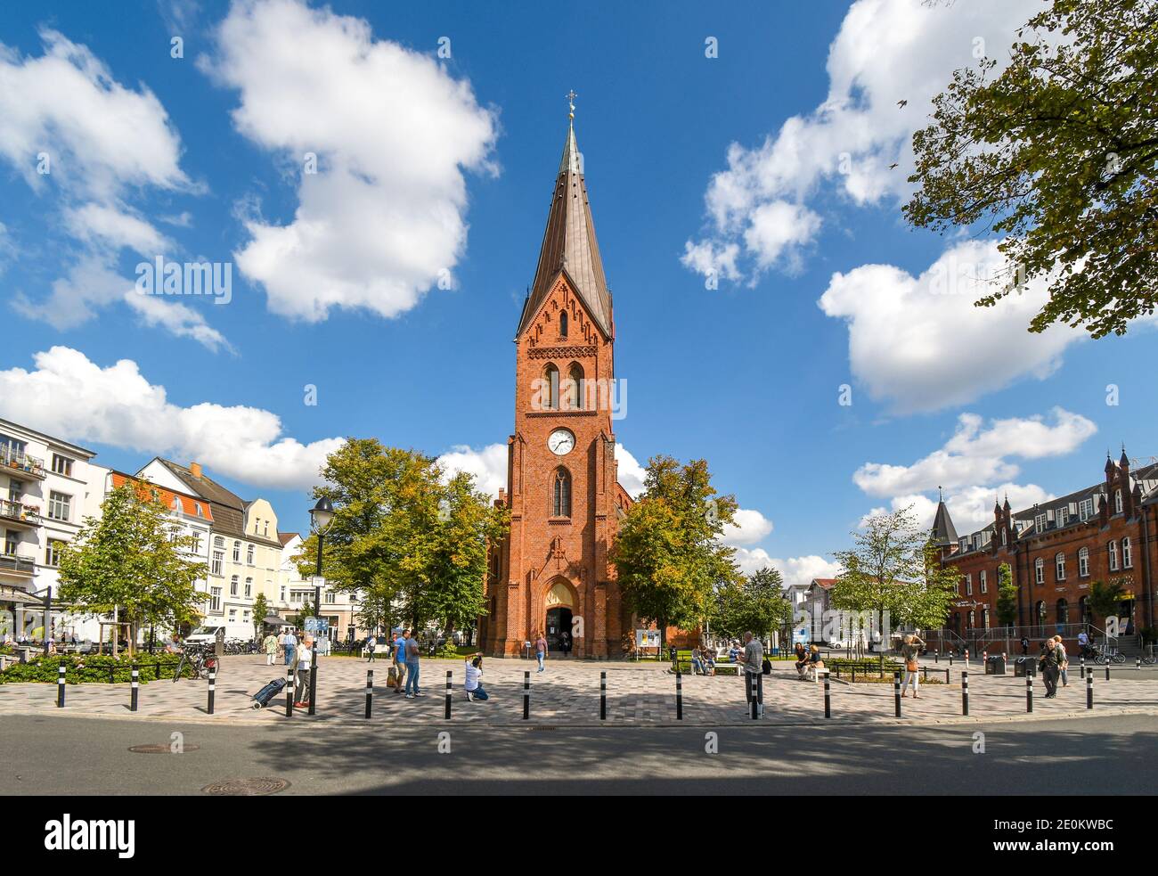 La tour de l'église néogothique de Warnemunde s'élève au-dessus de la ville côtière de Warnemunde Rostock, en Allemagne, tandis que les touristes et les habitants apprécient une belle journée d'été. Banque D'Images