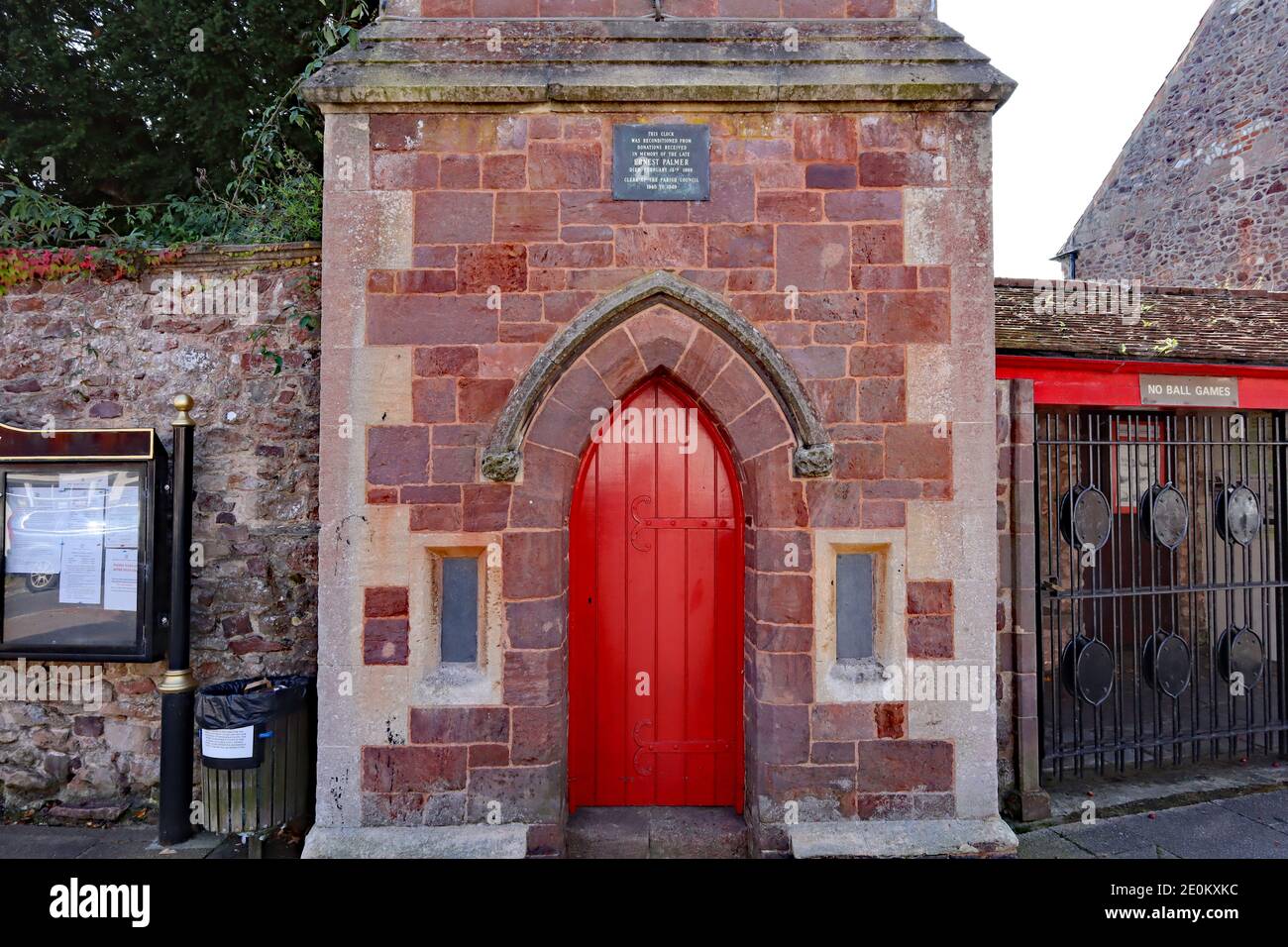 La porte rouge vif du haut de l'arche menant à l'horloge tour dans le  village de Nether Stowey dans Somerset Photo Stock - Alamy