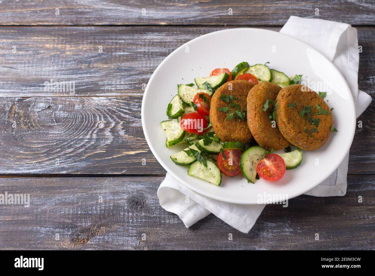 Côtelettes de carottes à l'amarante, salade de concombres frais et tomates sur une table en bois, espace libre. Délicieux plats maison sains Banque D'Images