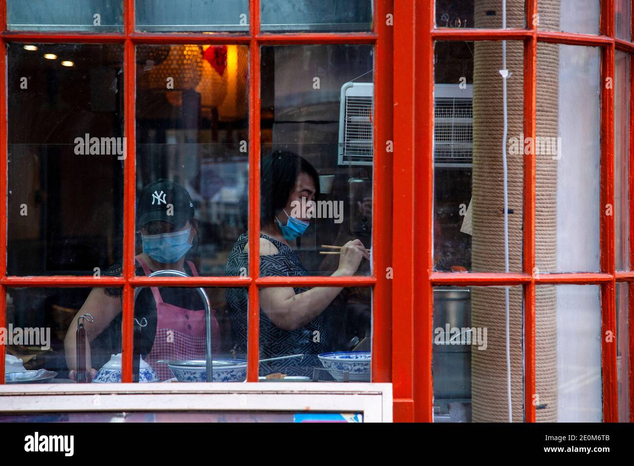 Deux femmes asiatiques travaillant dans la cuisine d'un restaurant portant des masques à Soho, Londres. Banque D'Images