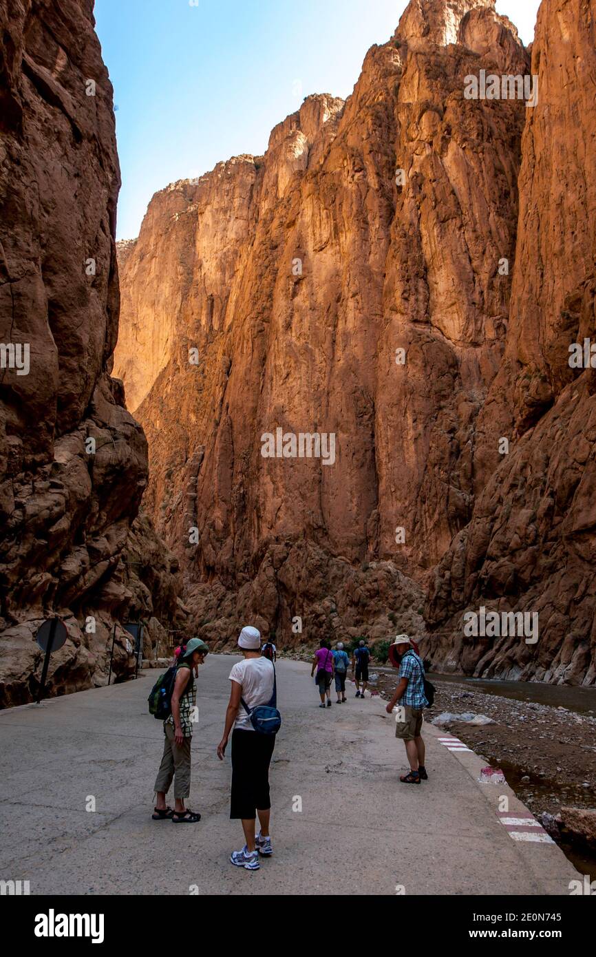 Touristes marchant dans la gorge de Todra à Tinerhir, Maroc. Todra gorge est un canyon de 160 mètres de haut dans la partie orientale des montagnes du Haut Atlas. Banque D'Images