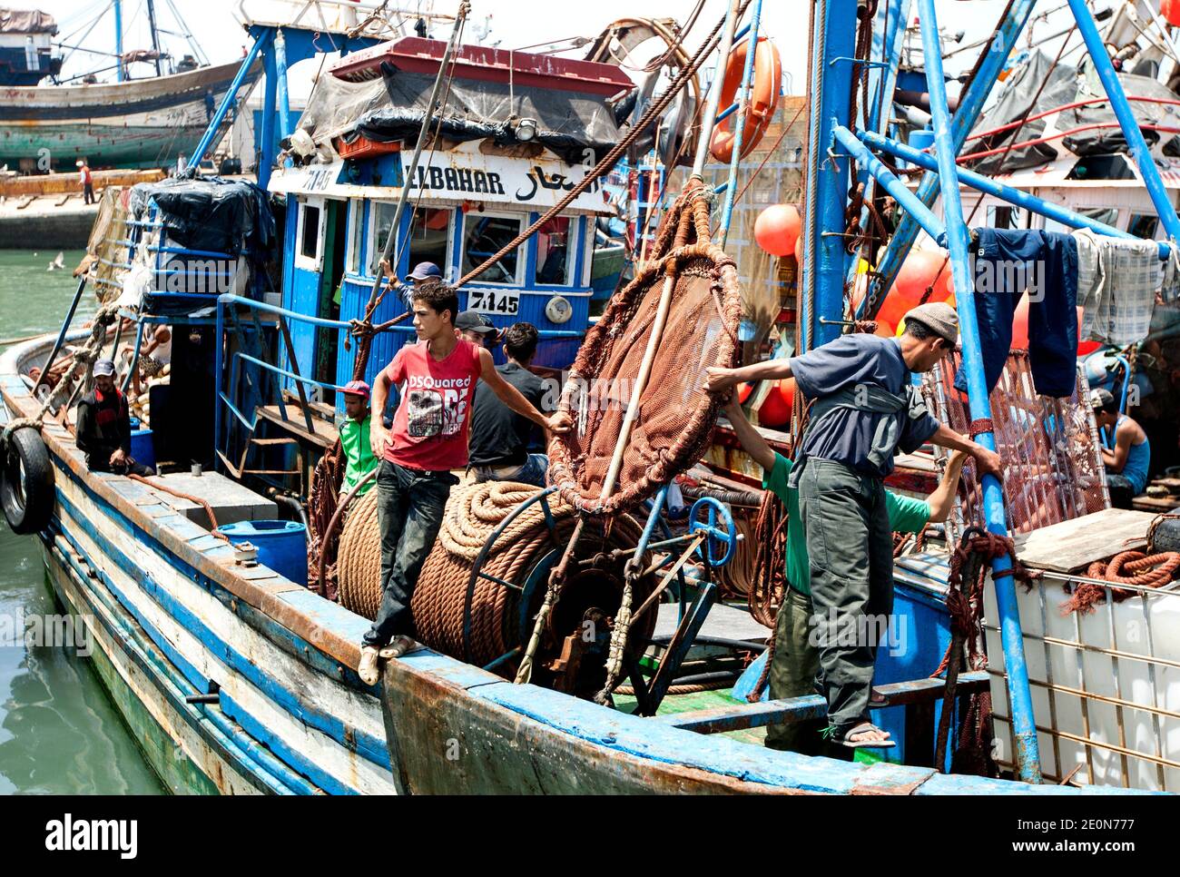 Les pêcheurs à bord de leur chalutier de pêche amarrés dans le port d'Essaouira, sur la côte atlantique du Maroc. Banque D'Images