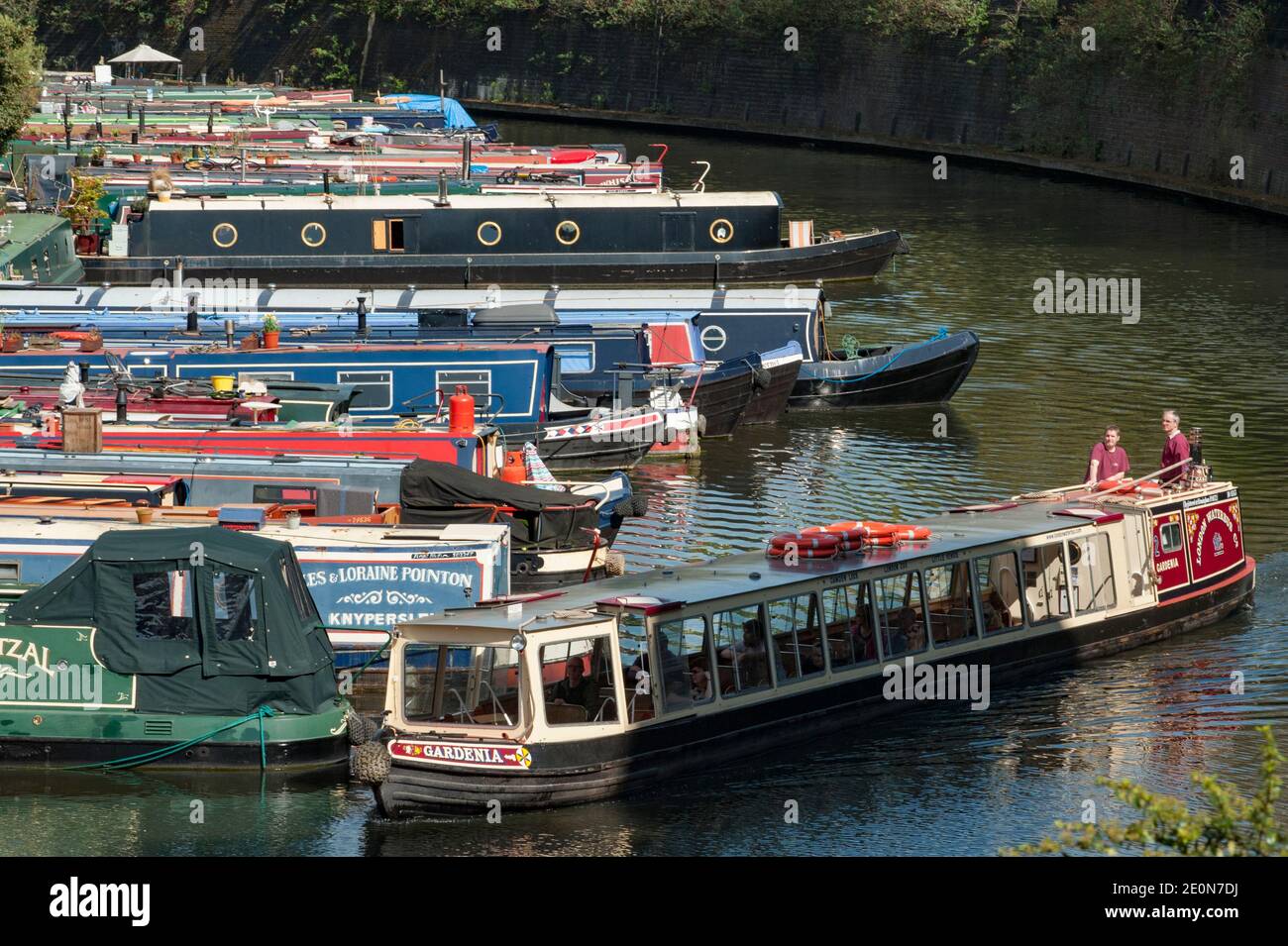 Le Gardenia, l'une des flottes de bateaux touristiques étroits appartenant à la London Waterbus Company, passe les bateaux de la maison amarrés en permanence juste à côté de Lisso Banque D'Images