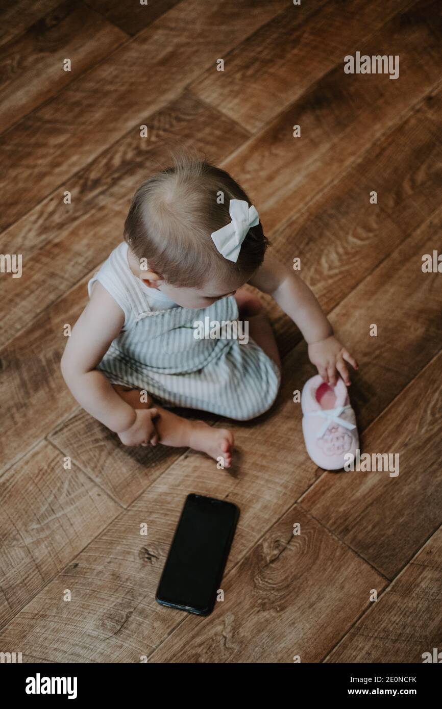 Adorable Petite Fille De Bebe Avec Un Telephone Cellulaire Pres Du Sol Portrait Vertical D Un Enfant Assis Au Sol Avec Un Telephone Portable Photo Stock Alamy