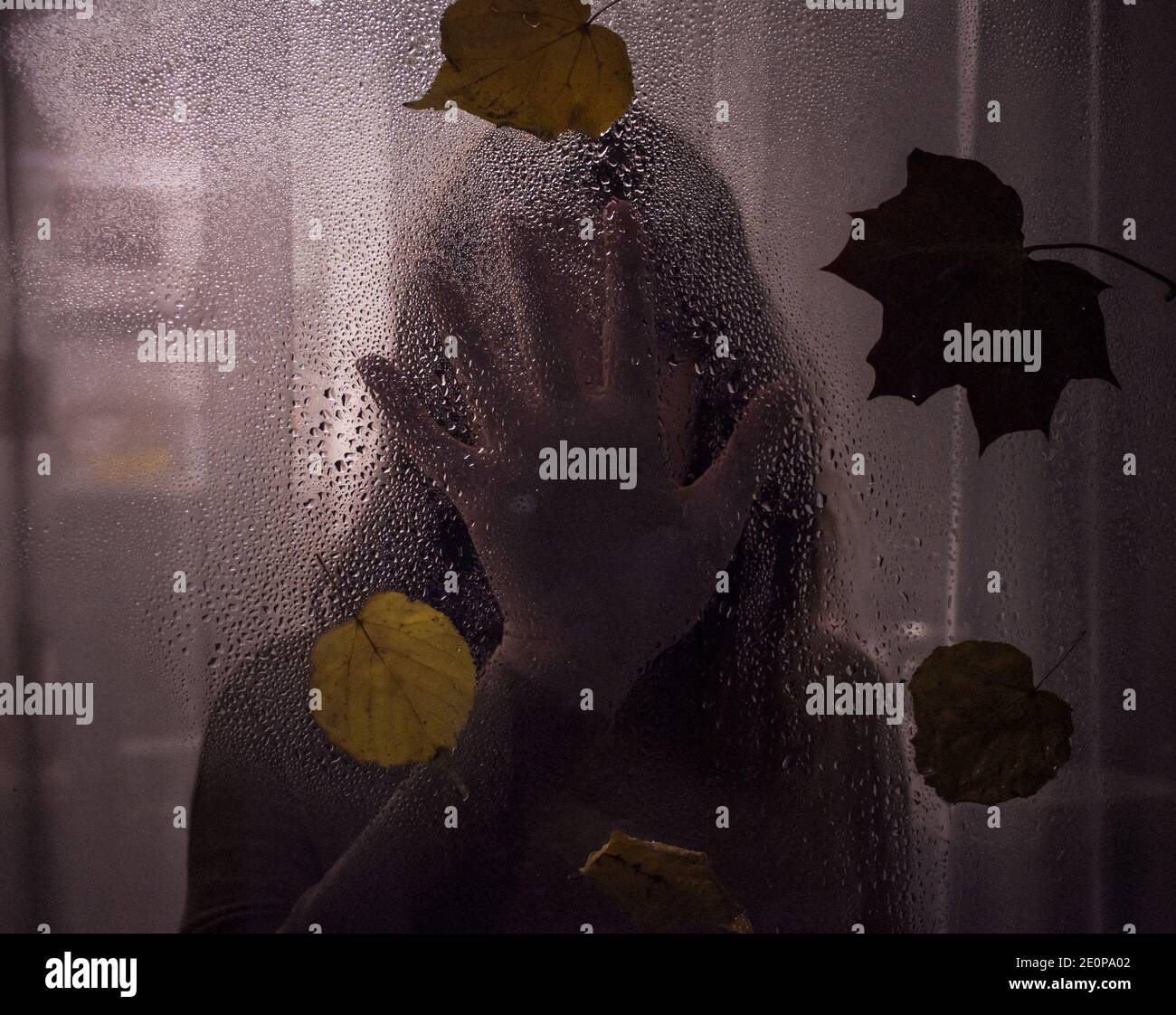 silhouette d'une femme derrière un verre humide. thriller Banque D'Images