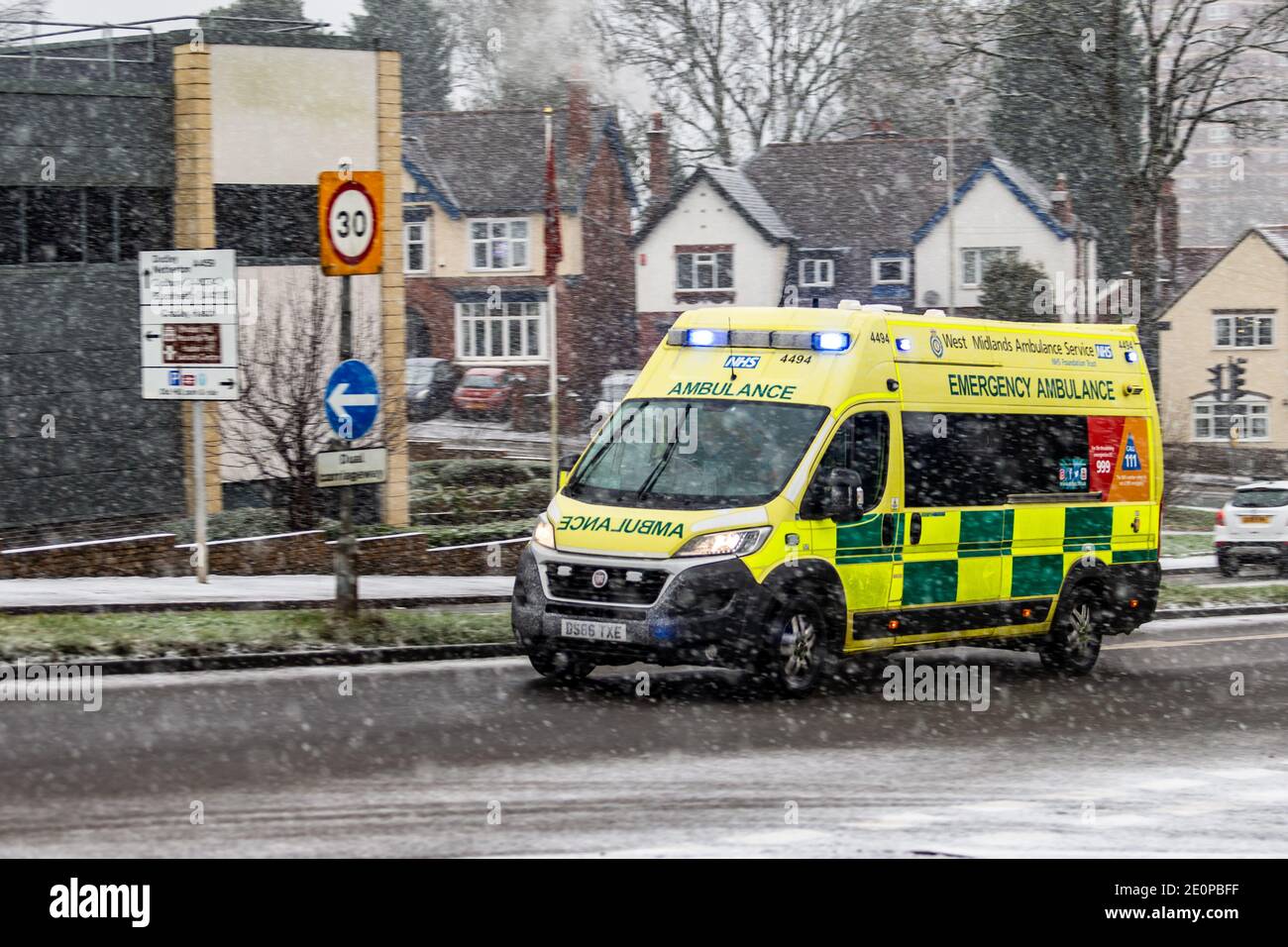 Une ambulance d'urgence traverse une chute de neige dans une ville, au Royaume-Uni Banque D'Images