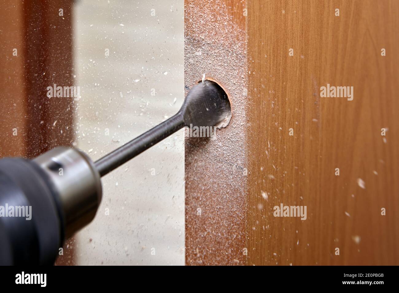 Le serrurier utilise une mèche plate pour le bois pour percer un trou de  poignée avec une serrure dans une porte intérieure en bois Photo Stock -  Alamy