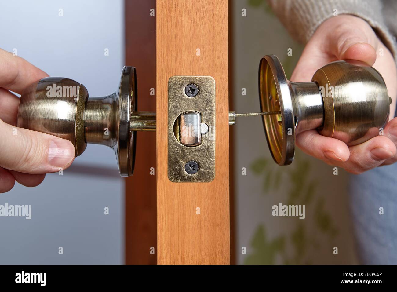 Réparation ou installation d'une poignée de porte. Le menuisier a aligné  l'autre moitié du bouton de porte avec la première Photo Stock - Alamy