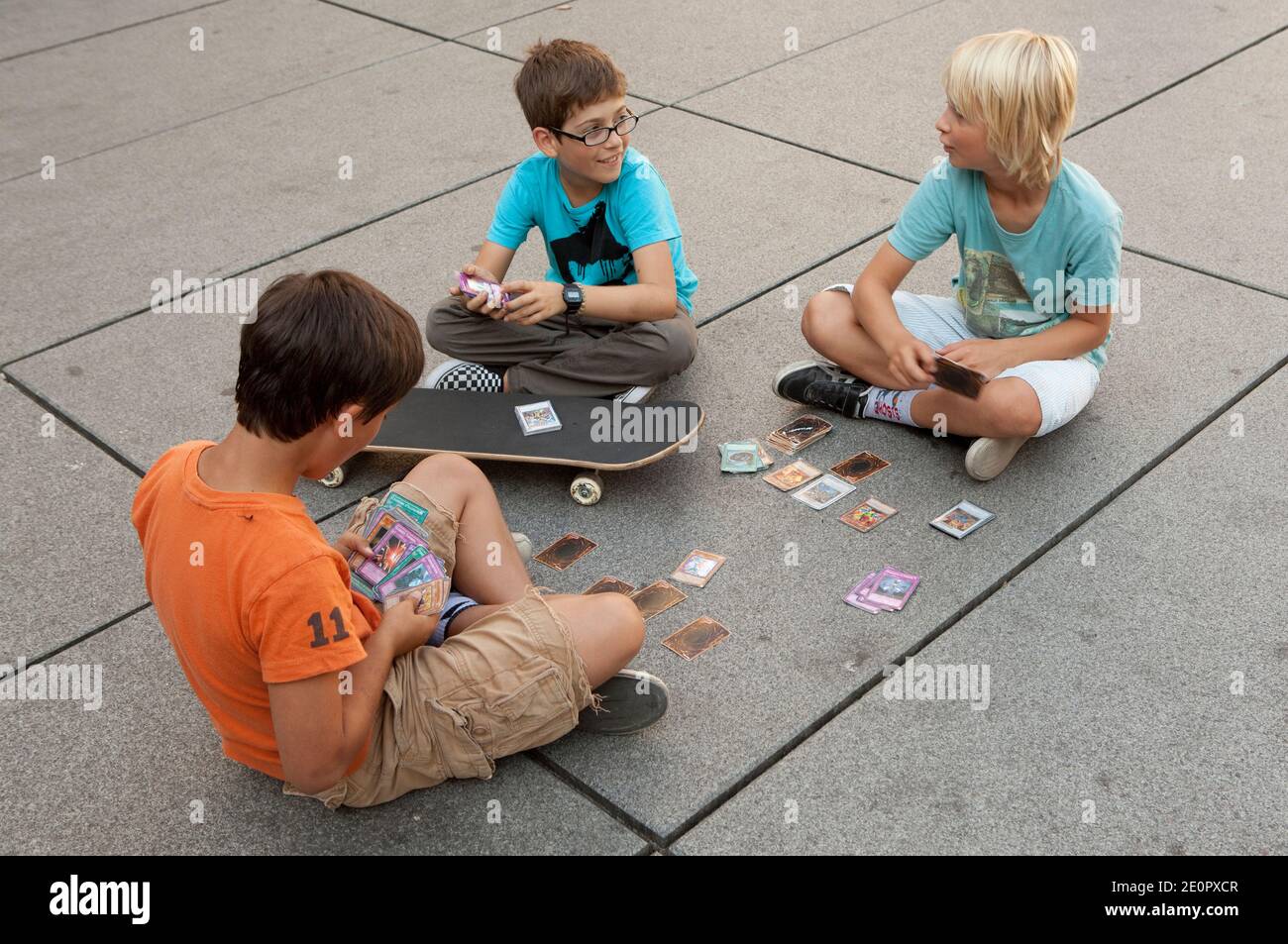 Trois garçons assis devant le Centre Pompidou jouant avec des cartes de crédit Banque D'Images