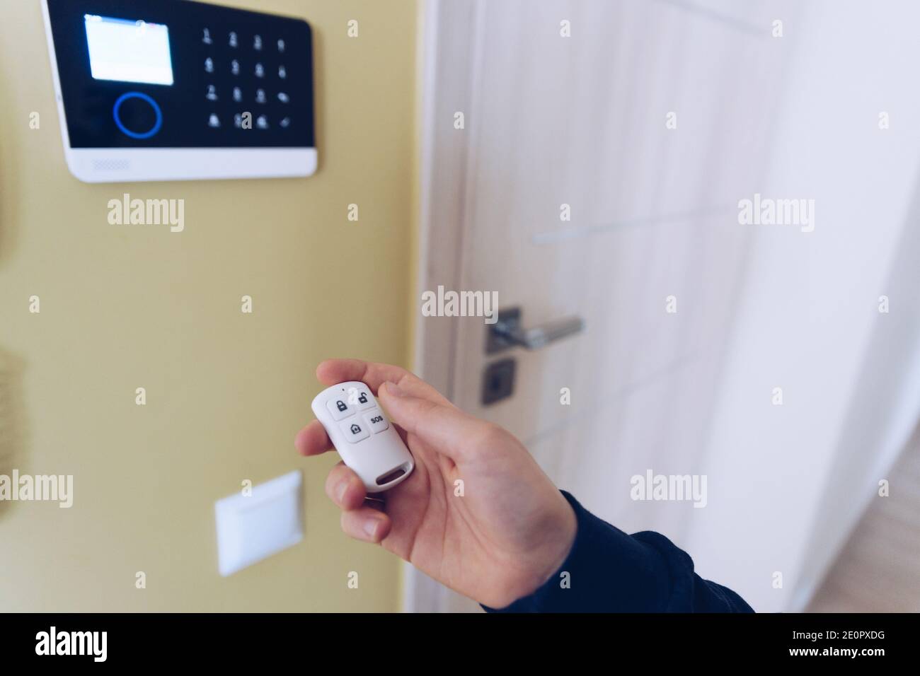 Un homme qui arme ou désarme un système d'alarme de sécurité à domicile, un  système d'alarme de sécurité à domicile Photo Stock - Alamy