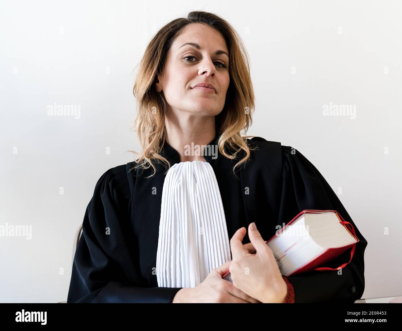 Avocate tenant le livre de droit rouge - Français Jeune beau femme avocate Banque D'Images