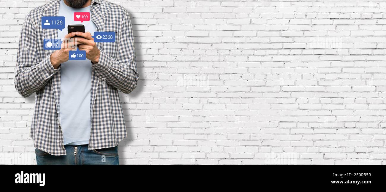 Concept de médias sociaux - bannière avec jeune homme tenant un smartphone et avec l'icône des réseaux sociaux Banque D'Images