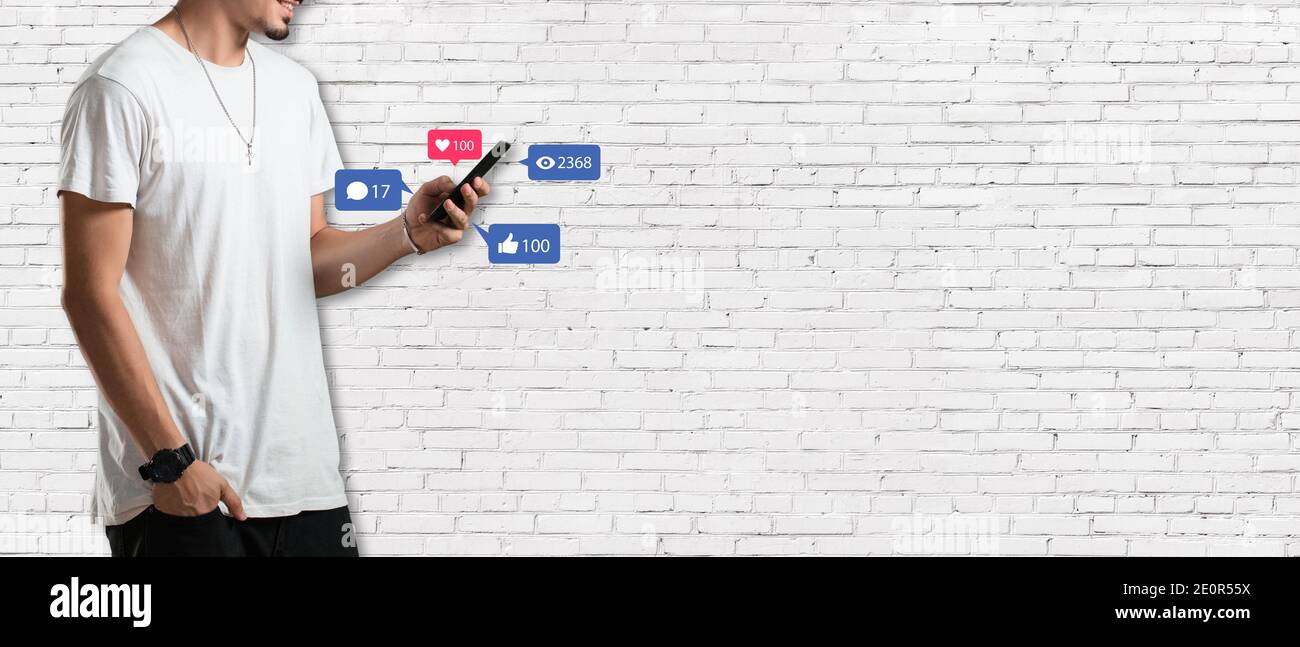 Concept de médias sociaux - bannière avec jeune homme tenant un smartphone et avec l'icône des réseaux sociaux Banque D'Images