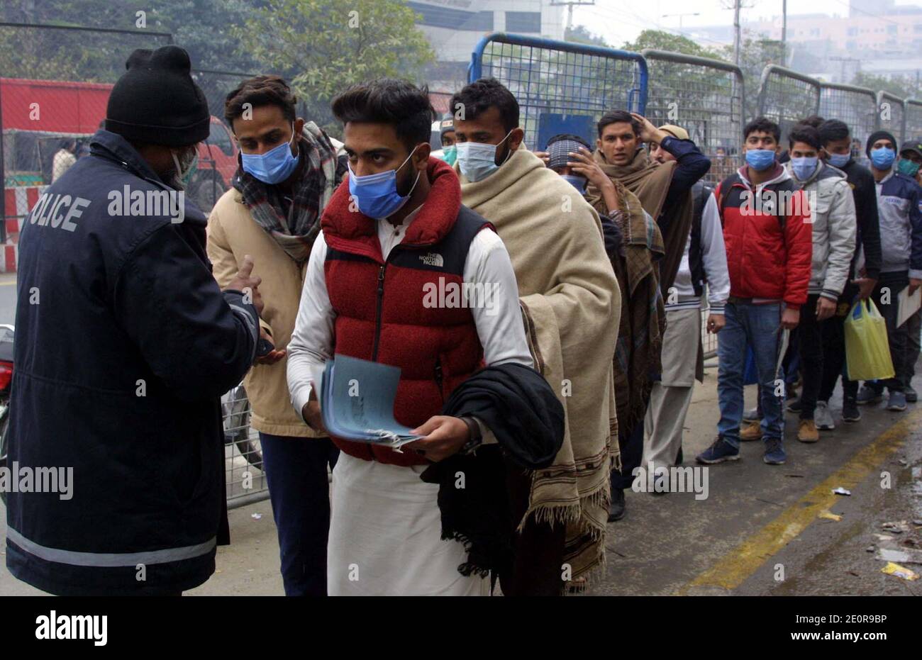 Les jeunes sont en file d'attente et attendent leur tour de soumettre des formulaires de demande d'emploi dans le département de police du quartier général des lignes de police à Lahore le samedi 02 janvier 2021. Banque D'Images