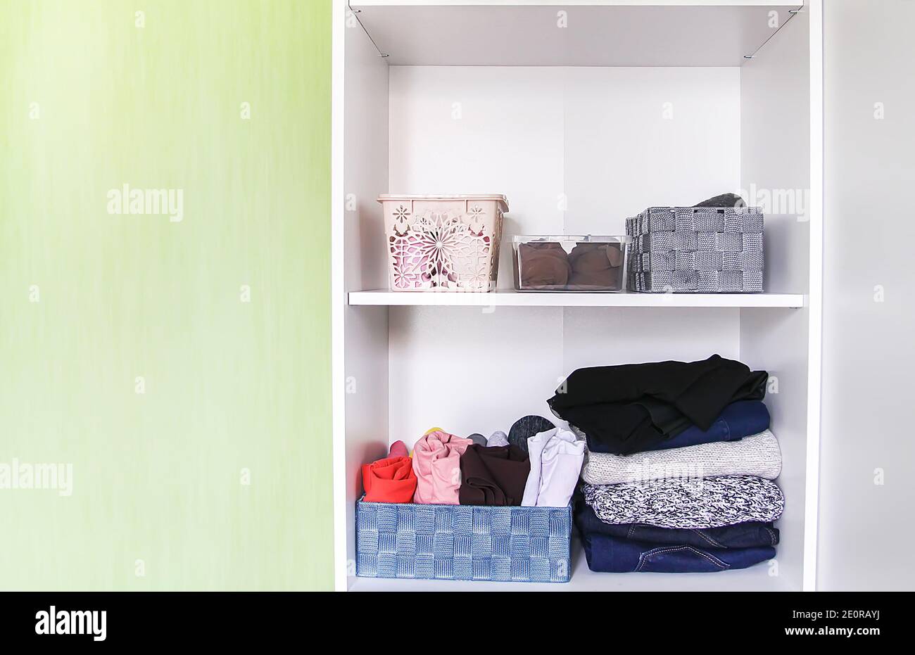 Différents vêtements dans l'armoire de la maison. Petite organisation de  l'espace. Stockage vertical Photo Stock - Alamy