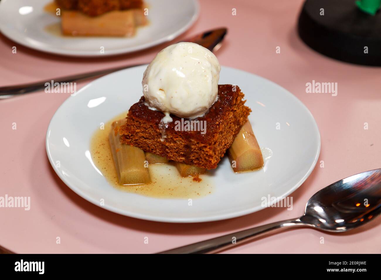 Une assiette de parkine traditionnel avec rhubarbe du yorkshire et glace crème sur fond de bois dans une cuisine Banque D'Images