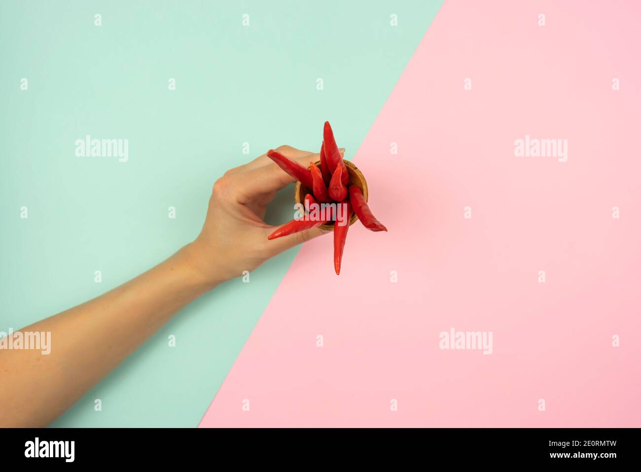 la main de la femme tient un cornet de gaufres avec des poivrons rouges chauds dans elle Banque D'Images