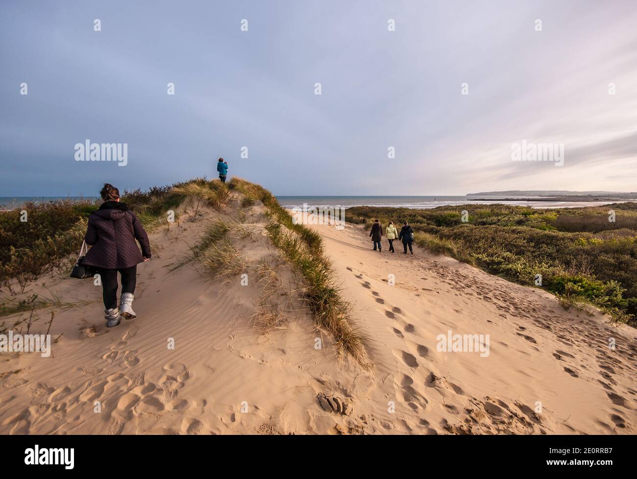 Plage de Camber Sands dans le village de Camber (près de Rye), East Sussex, Angleterre, Royaume-Uni. Personne, gens, marchant sur la dune vers la plage et la mer Banque D'Images