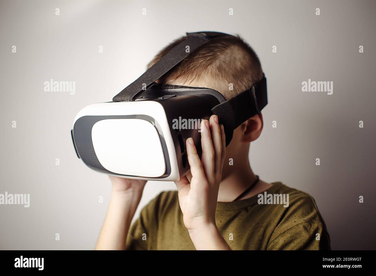 Garçon jouant à l'application de jeu mobile sur les lunettes de réalité  virtuelle de l'appareil sur fond blanc. Action garçon et utilisation dans  un casque virtuel, VR Box pour une utilisation avec