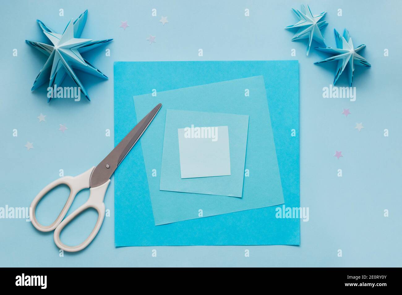 Arbre de Noël en relief origami simple en papier bleu. Instructions étape par étape, étape 1. Préparez des feuilles de papier carrées de différentes couleurs et de différents formats Banque D'Images