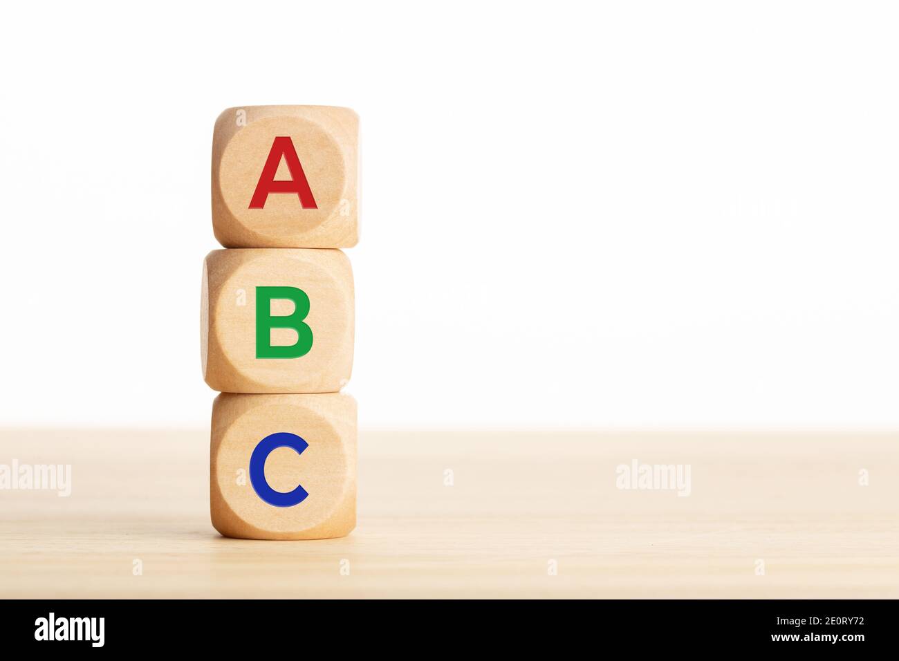 Lettres ABC sur des blocs de bois empilés sur une table en bois. Arrière-plan blanc. Copier l'espace Banque D'Images