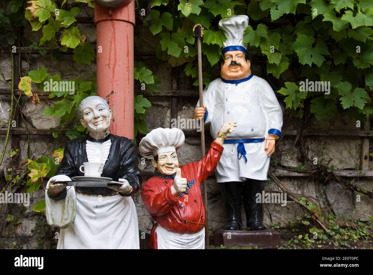 Des chefs et serveuses en costume autrichien traditionnel accueillent les invités dans un restaurant à Hallstatt, un village pittoresque d'Autriche. Banque D'Images