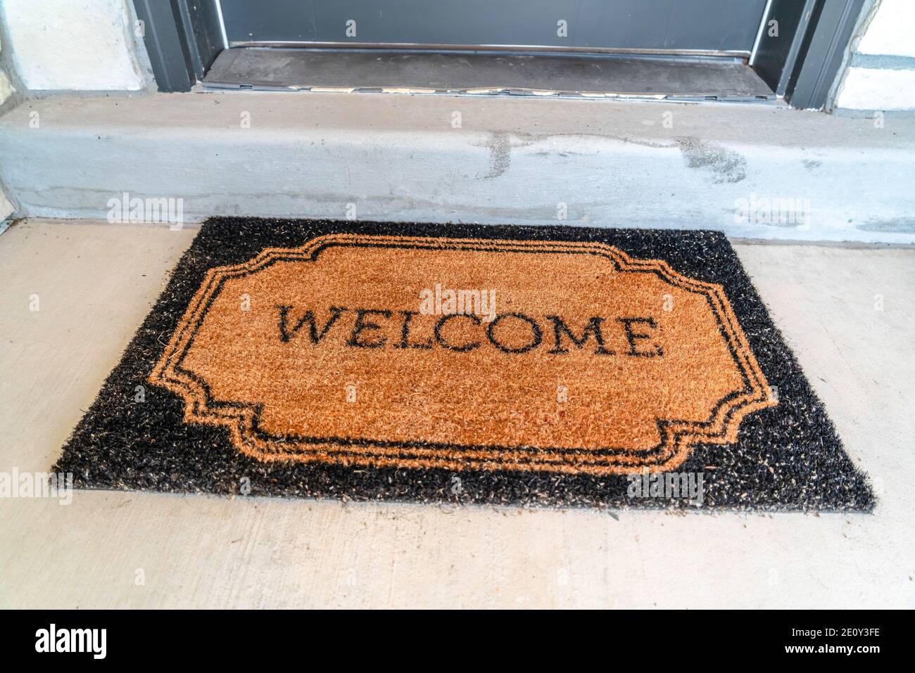 Entrée de la maison avec tapis de bienvenue devant le seuil de porte et  porte avant grise Photo Stock - Alamy