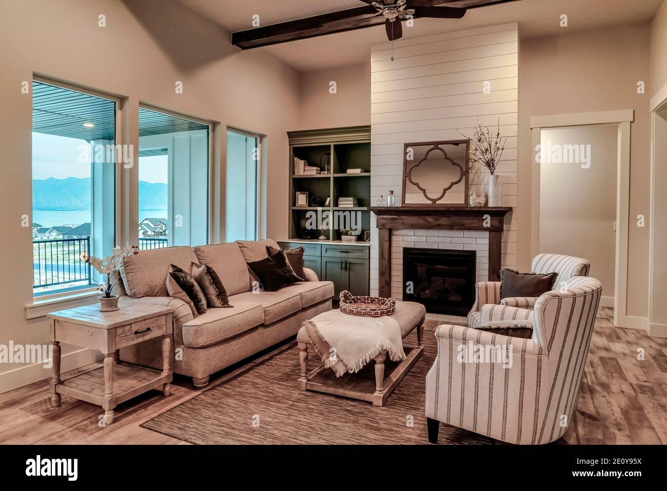 Salle de séjour de la maison avec meubles rembourrés foyer moderne et  ventilateur de plafond Photo Stock - Alamy