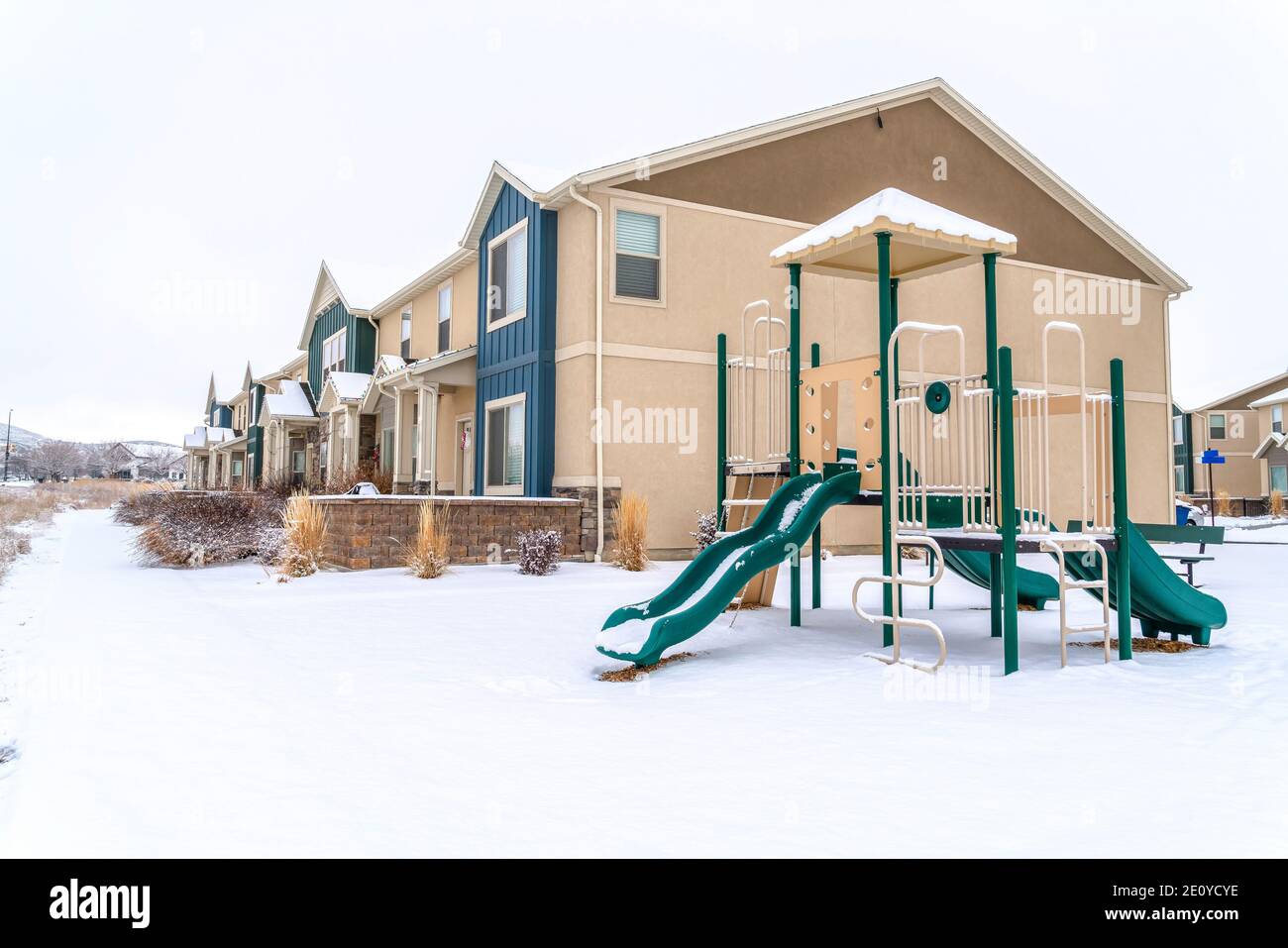 Quartier avec aire de jeux et maisons contre la neige nature dans hiver Banque D'Images