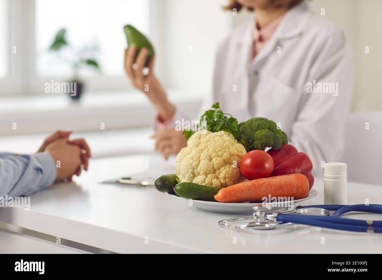 Gros plan d'une assiette avec des légumes sur le fond d'un nutritionniste qui fournit la consultation. Banque D'Images