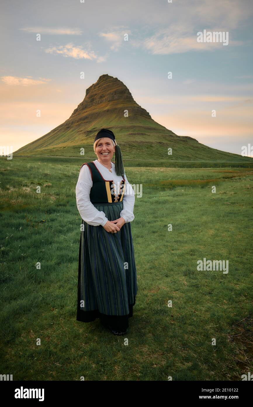 Femme islandaise locale portant la robe traditionnelle nationale Upplutur avec chapeau de queue, Kirkjufell Kirkjufellsfoss à Grundarfjörður, Snæfellsnes, Islande Banque D'Images