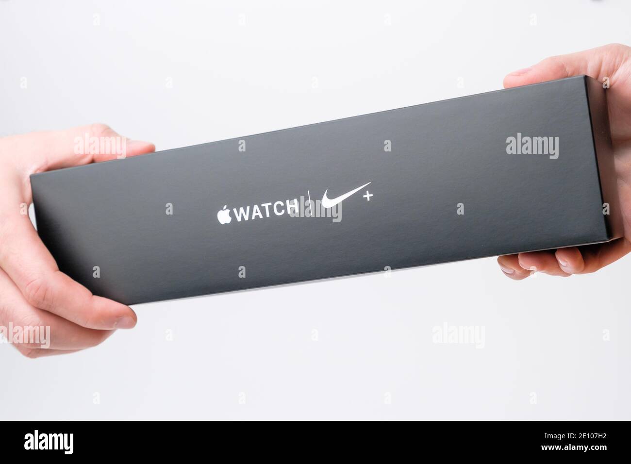 Homme et femme main tenant une boîte avec Apple Watch Nike plus sur fond gris, décembre 2020, San Francisco, États-Unis Banque D'Images