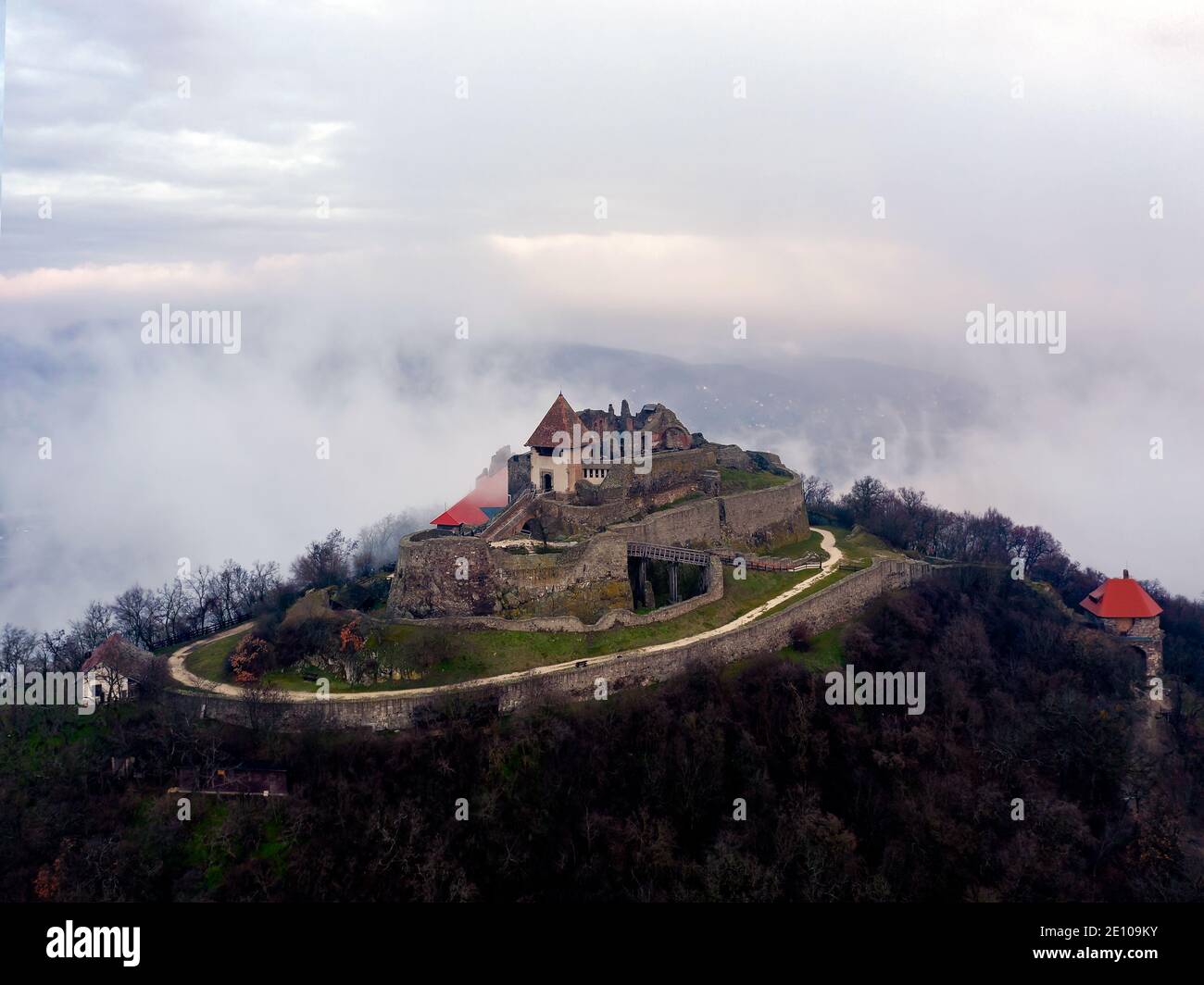 Les ruines du château de la citadelle de Visegrad dans la courbe du Danube en Hongrie. Paysage aérien fantastique par mauvais temps. Lever de soleil brumeux et nuageux Banque D'Images