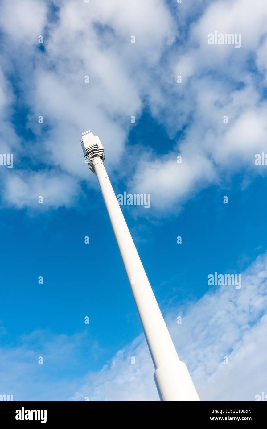 5g Telecom Mast dans un cadre urbain près d'une route principale et d'un logement avec ciel bleu et espace de copie à Bradford, West Yorkshire Banque D'Images